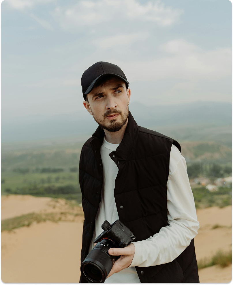 Julian Voss on location, camera in hand, overlooking a valley